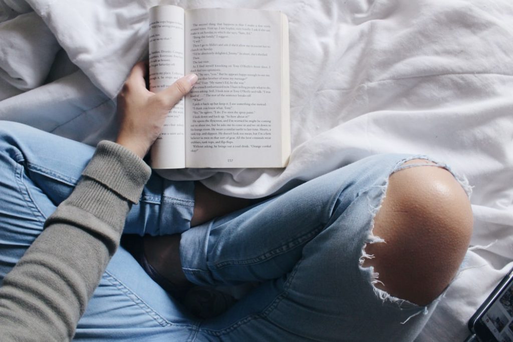 girl reading a book in bed